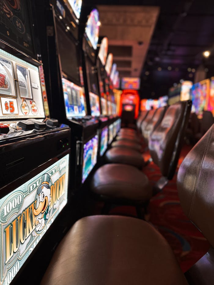 A row of casino slot machines glowing at night, creating a lively gaming atmosphere indoors.