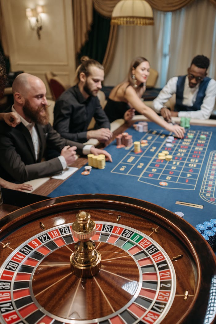 Group of diverse people enjoying a thrilling game of roulette in a luxurious casino setting.